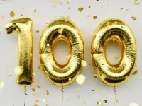 "100" spelled out in golden balloons